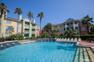 A swimming pool with Adirondack chairs at the side